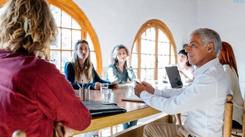 Menschen an einem Tisch bei der Planung von Architektur in der Psychiatrie