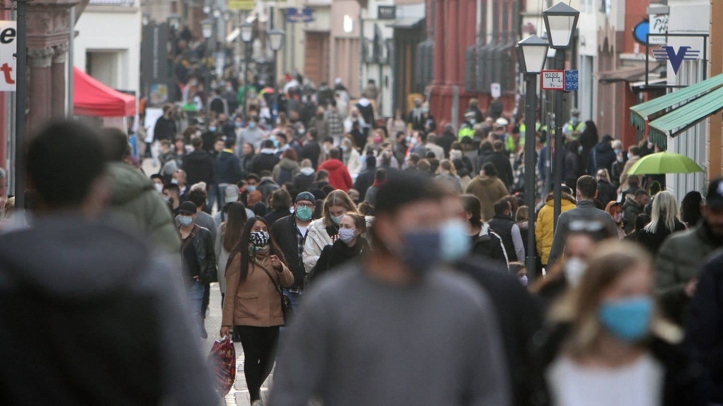 Einkaufsstraße voller Menschen mit Maske