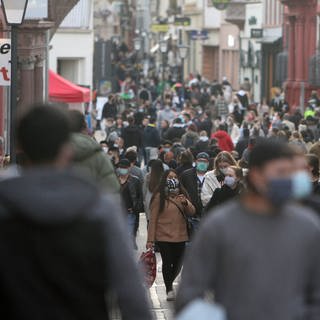 Einkaufsstraße voller Menschen mit Maske