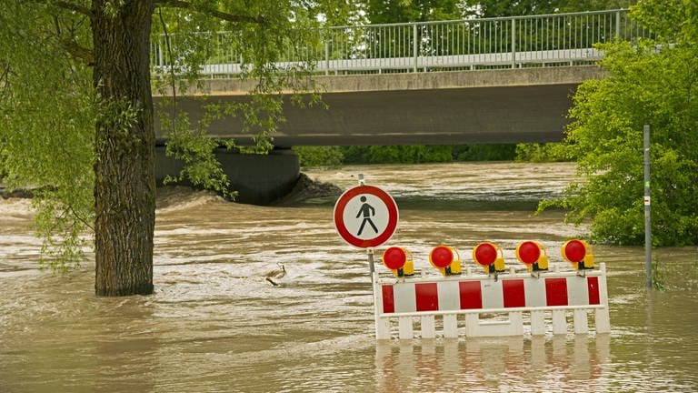 Forschende an der Uni Freiburg entwickeln derzeit einen Index, der die Gefahren von Sturzfluten einordnen soll | Überfluteter Weg mit Warnschild