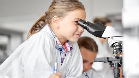 Mädchen sieht in ein Mikroskop, tags: Kinder, Eltern, Wissenschaft, Wissen, Bildung, wissenschaftliche