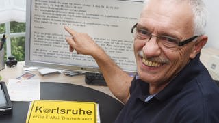Michael Rotert zeigt auf die erste in Deutschland empfangene E-Mail, die er vor 40 Jahren an der Universität Karlsruhe in Deutschland erhielt.