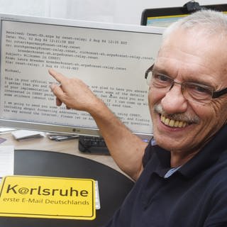 Michael Rotert zeigt auf die erste in Deutschland empfangene E-Mail, die er vor 40 Jahren an der Universität Karlsruhe in Deutschland erhielt.