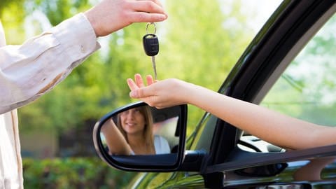 Symbolbild: Überreichen der Autoschlüssel nach bestandener Führerscheinprüfung. ChatGPT wäre nicht fahrtauglich.