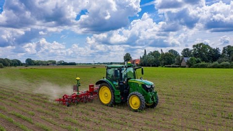 Selbstfahrende Traktoren fahren mit Mähdrescher übers Feld.