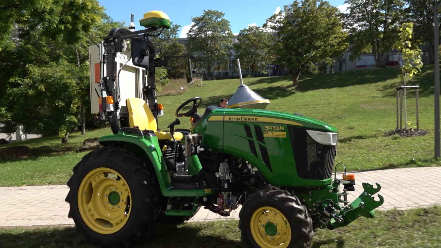 Ein kleiner, autonomer Traktor steht auf dem Campus der Uni Kaiserslautern-Landau.