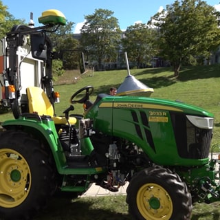 Ein kleiner, autonomer Traktor steht auf dem Campus der Uni Kaiserslautern-Landau.