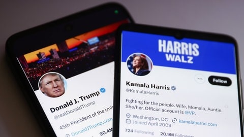 Zwei Handybildschirme, auf einem der X-Account von Donald Trump, auf dem anderen der X-Account von Kamala Harris, tags: Desinformation Rolle spielt USA Fake