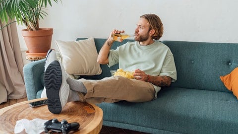 Ein Mann auf der Couch mit Bier und Chips, tags: Fakten Männergesundheit Männer Fakten Gesundheit