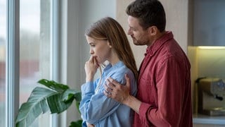 Mann hält traurige Frau im Arm, tags: Familie Depression Depressionshilfe