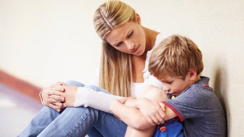 Frau mit traurigem Kind. Durch die Stärkung der Selbstwirksamkeit von Kindern und Jugendlichen in der Schule könnte sich die psychische Gesundheit verbessern.