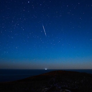 Die Geminiden lassen sich bei günstigen Bedingungen im Dezember am Nachthimmel beobachten. 2024 könnte die Beobachtung der Sternschnuppen allerdings durch den Vollmond erschwert werden.  