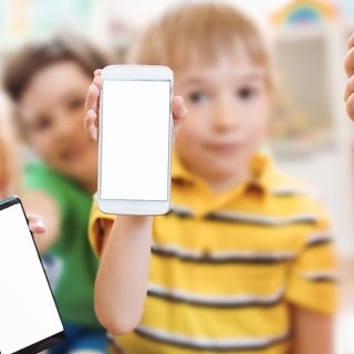 Kinder halten Smarphones. Smartphones Kinder Gefahren